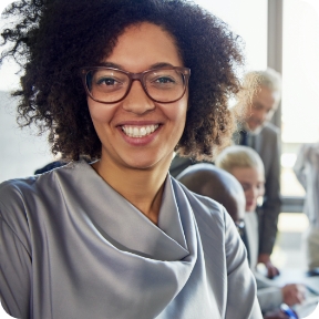 Woman sits in office and smiles at the camera.